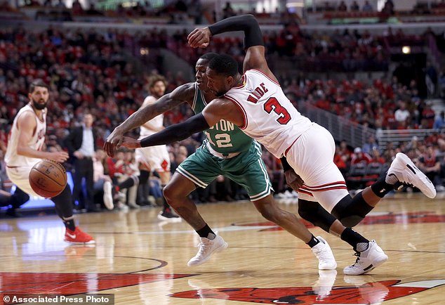 Chicago Bulls Dwyane Wade and Boston Celtics Terry Rozier battle for a loose ball during the first quarter of Game 3 of a first-round NBA playoff basketball series in Chicago Friday