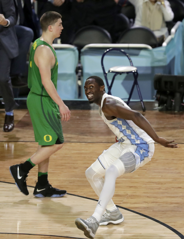 North Carolina’s Theo Pinson right celebrates as Oregon’s Payton Pritchard walks off the court after the semifinals of the Final Four NCAA college basketball tournament Saturday