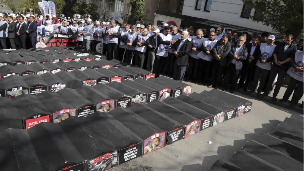 Members of a Turkish trade union pray for victims after a chemical weapons attack killed more than 80 people in northern Syria