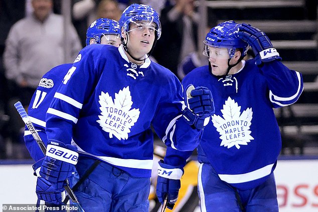 Toronto Maple Leafs center Auston Matthews reacts to a goal next to teammates Morgan Rielly and Zach Hyman, during the third period of an NHL hockey game against the Toronto Maple Leafs in Toronto on Saturday