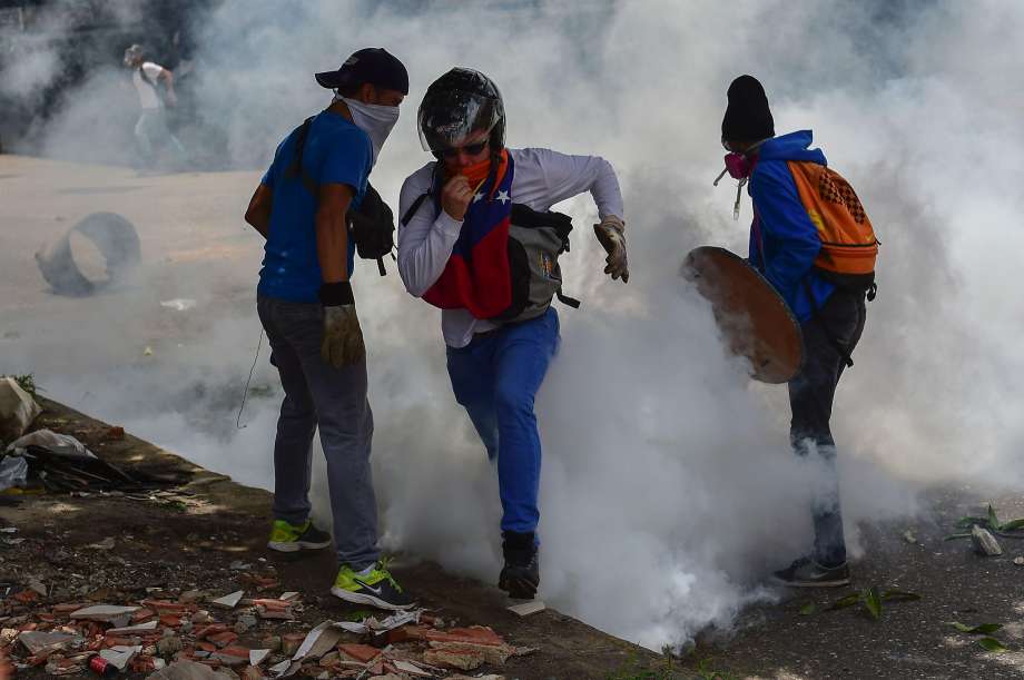 Opposition demonstrators clash with riot police officers during a protest against the government of Venezuelan President Nicolas Maduro in the capital Caracas