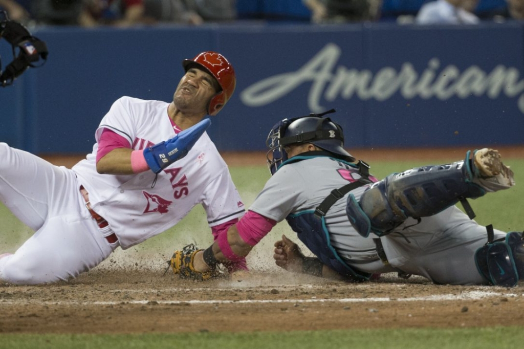 Blue Jay Devon Travis steals home past diving Mariners catcher Carlos Ruiz in the eighth inning on Saturday