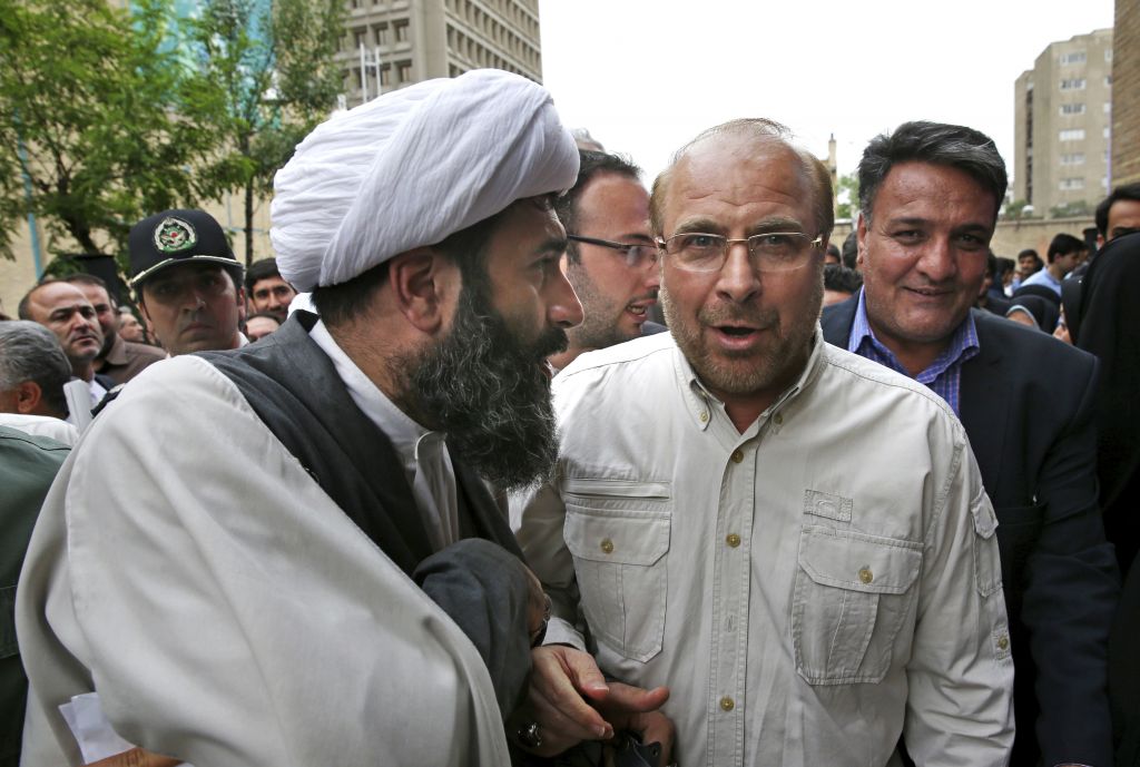 Tehran's mayor and conservative presidential candidate Mohammad Bagher Qalibaf center right listens to a cleric on his arrival to attend a campaign rally in Tehran Iran