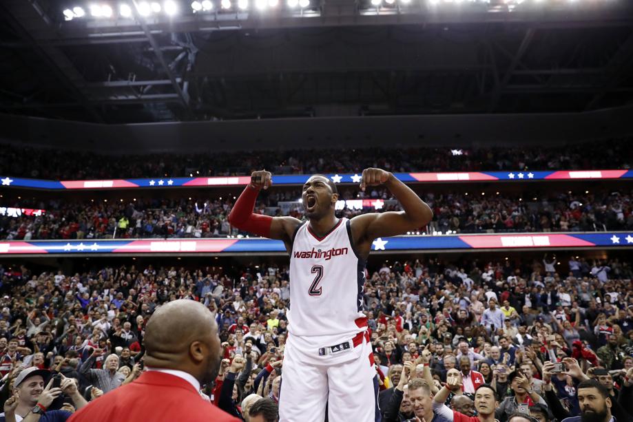 Washington Wizards guard John Wall celebrates as he stands on the scorer's table after Game 6 against the Boston Celtics in an NBA basketball second-round playoff series Friday