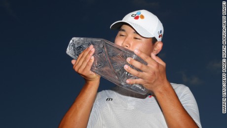 Kim Si Woo of South Korea celebrates with the winner's trophy after the final round of the 2017 Players Championship