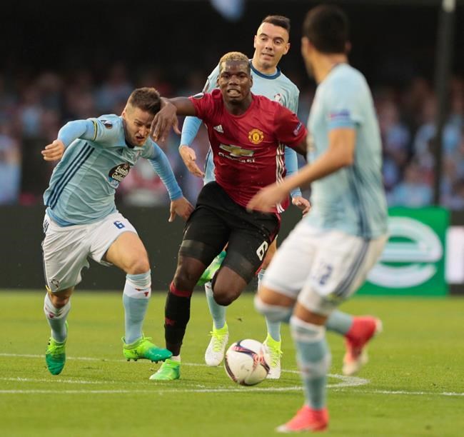 Manchester United's Paul Pogba center runs past Celta's Nemanja Radoja left and Iago Aspas during a Europa League semifinal first leg soccer match between Celta and Manchester United at the Balaidos stadium in Vigo Spain Thursday