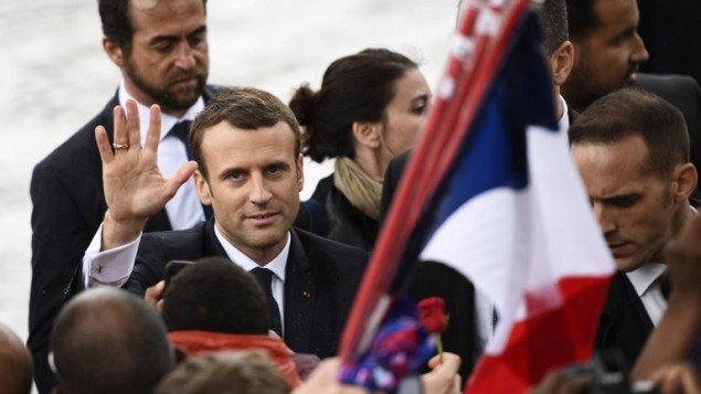 French President Emmanuel Macron greets people after laying a wreath of flower on the unknown Soldier's tomb at the Arc of Triomphe monument after his formal inauguration ceremony as French President