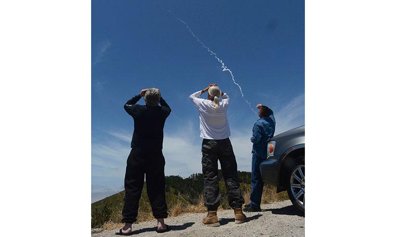 Spectators watch an interceptor missile launch from an underground silo at Vandenberg Air Force Base in California and fly toward an intercontinental-range missile fired from a test range on Kwajalein Atoll in the Pacific. LEN WOOD /THE SANTA MARIA TIMES