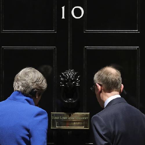 Minister Theresa May and her husband Philip stand on the doorstep of 10 Downing street London after addressing the press Friday