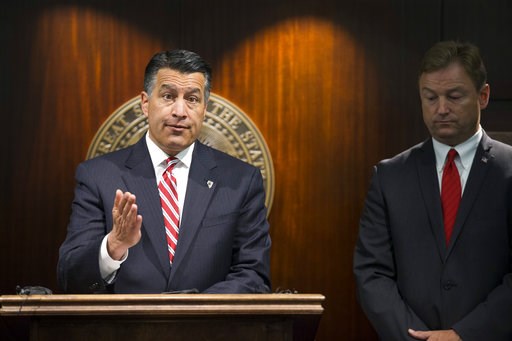 Gov. Brian Sandoval left and U.S. Sen. Dean Heller R-Nev. give a news conference in Las Vegas where the senator announced he will vote no on the propo