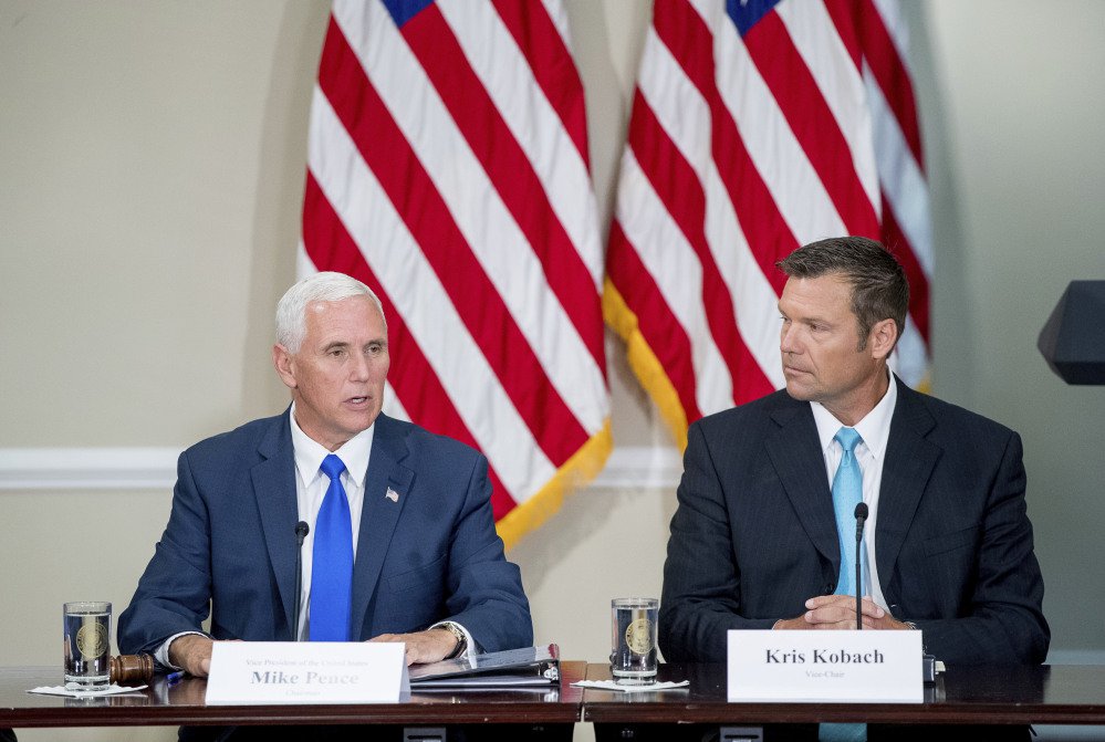 Vice President Mike Pence left with Kansas Secretary of State Kris Kobach speaks during the meeting of the president's voter fraud panel