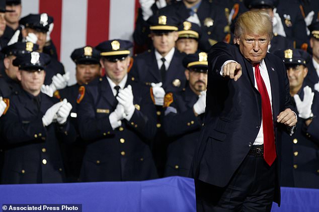 President Donald Trump points to the crowd after speaking to law enforcement officials on the street gang MS-13 Friday