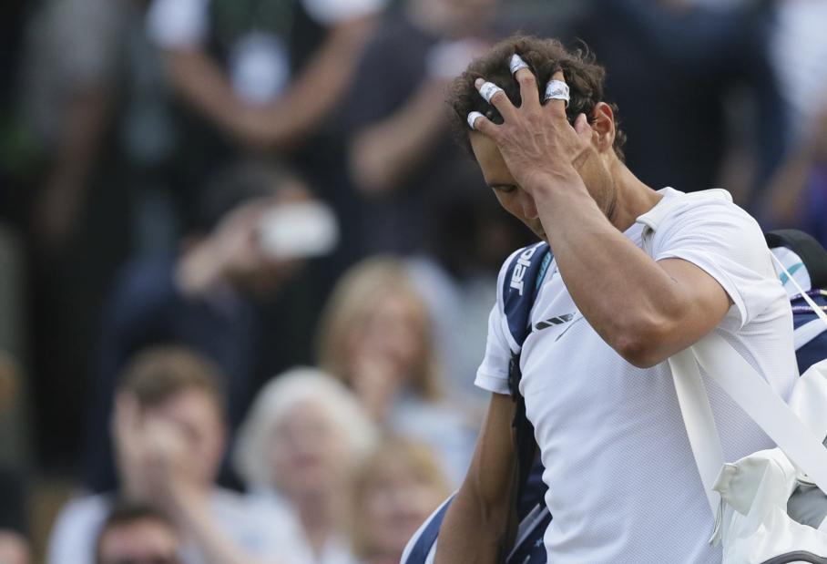 Spain's Rafael Nadal leaves the court after losing to Luxembourg's Gilles Muller in their Men's Singles Match on day seven at the Wimbledon Tennis Championships in London Monday