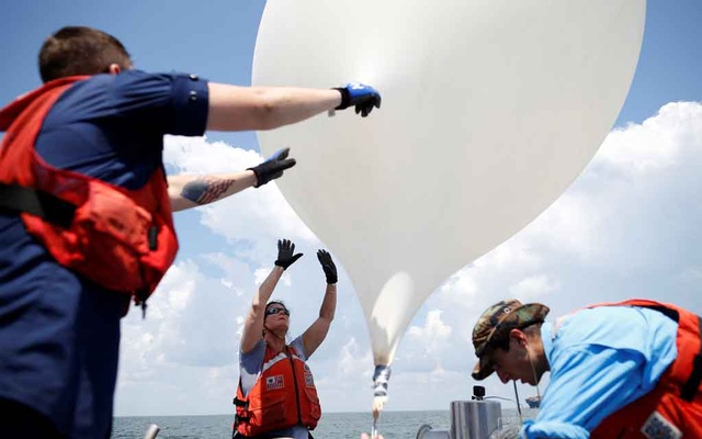 College of Charleston professor Dr Cassandra Runyon releases a balloon during a test launch for the Space Grant Ballooning Project in preparations for Monday's solar eclipse on board a US Coast Guard response boat at sea near Charleston South Ca