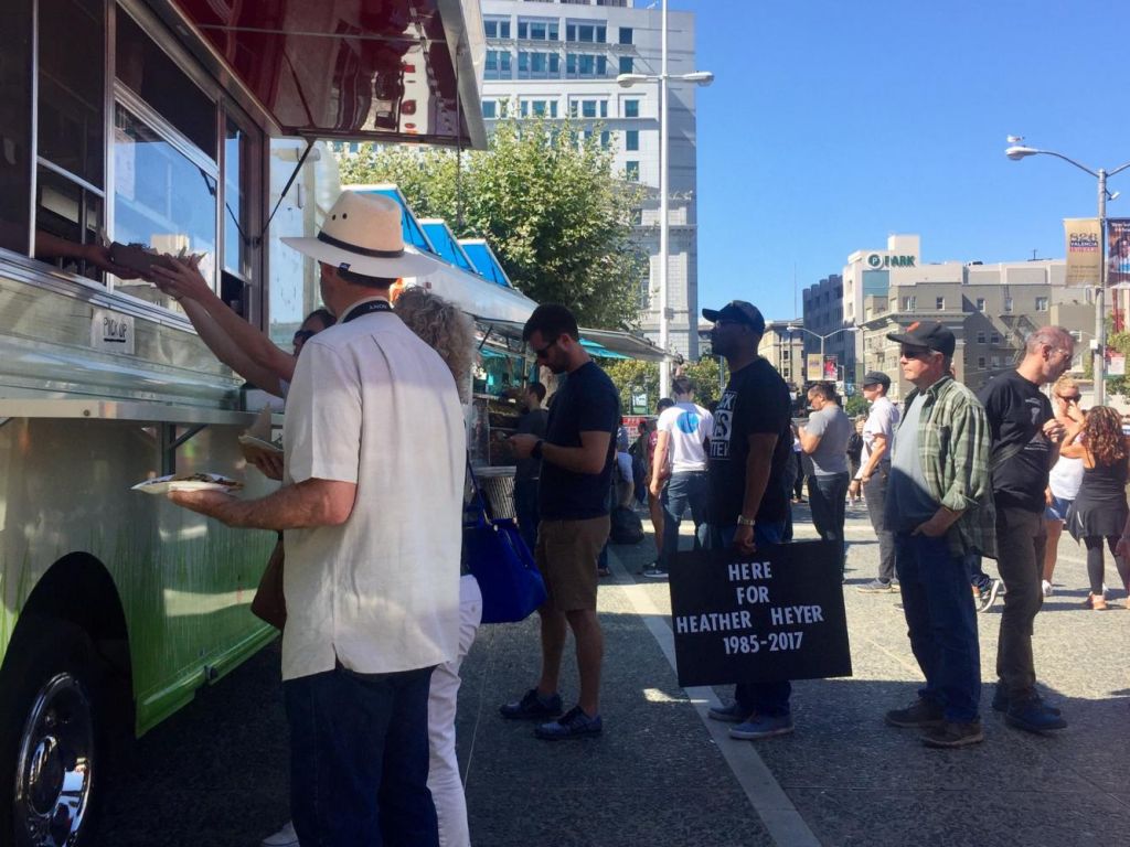 Peaceful protesters stand in line to buy food from a food truck at the rally. One man holds