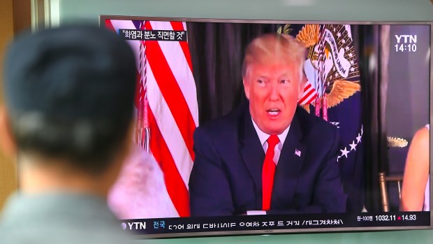 A man watches a television news program showing President Trump at a railway station in Seoul on Wednesday. Trump warned North Korea on Tuesday that it faces'fire and fury over its missile program