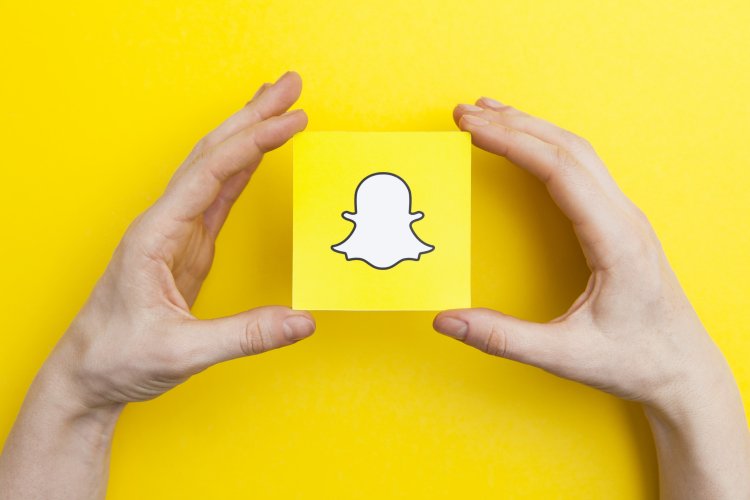 Hands holding Snapchat logo