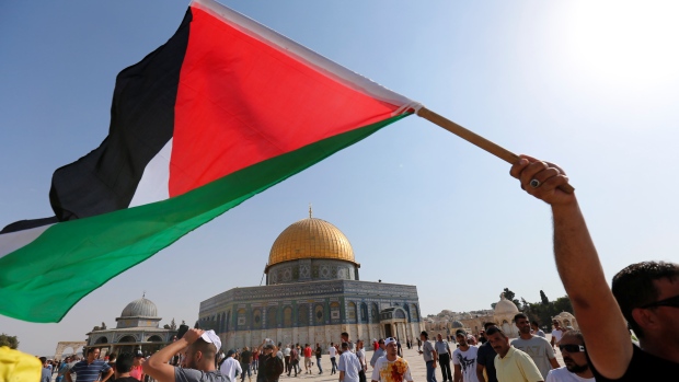 A man waves a Palestinian flag upon entering the compound known to Muslims as the Haram al Sharif and to Jews as Temple Mount after Israel removed all security measures it had installed at the compound in Jerusalem's Old City