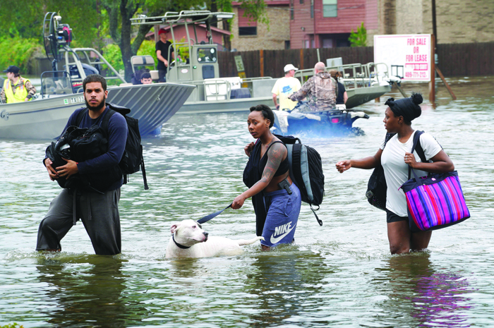 People walk through floodwaters from Hurricane Harvey Aug. 27 after being evacuated in Dickinson Texas