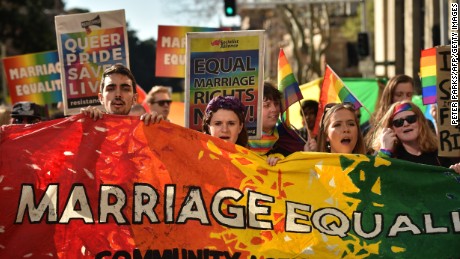 Supporters of same sex marriage carry banners and shout slogans as they march in Sydney on August 6