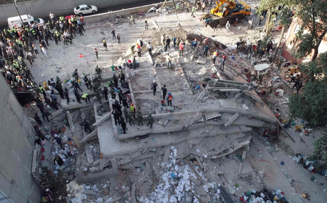 GONE Rescuers look for survivors in a multistory building flattened by the 7.1 magnitude quake. AFP