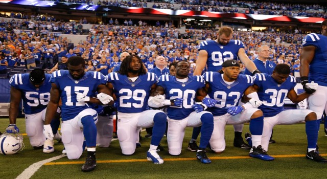 Members of the Indianapolis Colts stand and kneel for the national anthem on Sunday