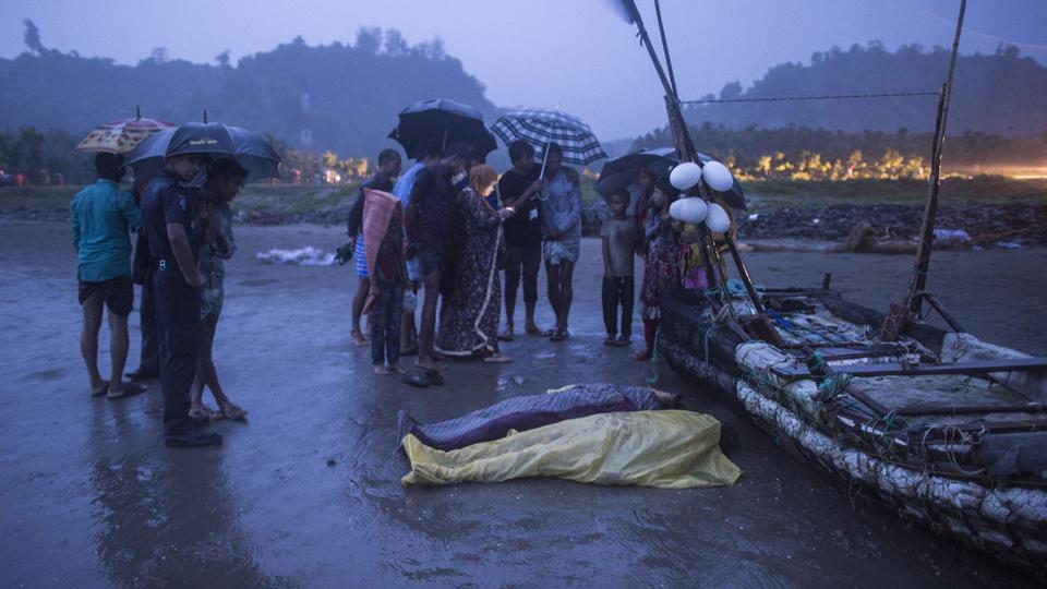 People gather around bodies of Rohingya Muslim refugees on the shore of Inani beach near Cox's Bazar on September 28