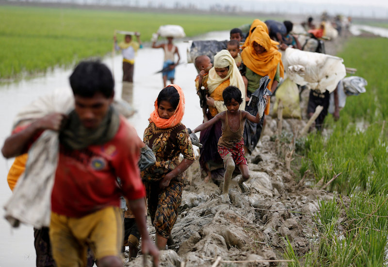 Rohingya refugees walk on the muddy path after crossing the Bangladesh Myanmar border in Teknaf Bangladesh