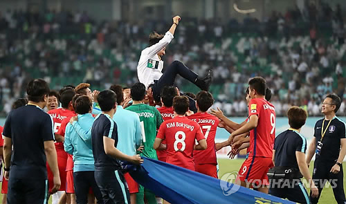 South Korean players throw their head coach Shin Tae-yong in the air in celebration after qualifying for the 2018 FIFA World Cup following a scoreless draw against Uzbekistan at Bunyodkor Stadium in Tashkent on Sept. 5 2017