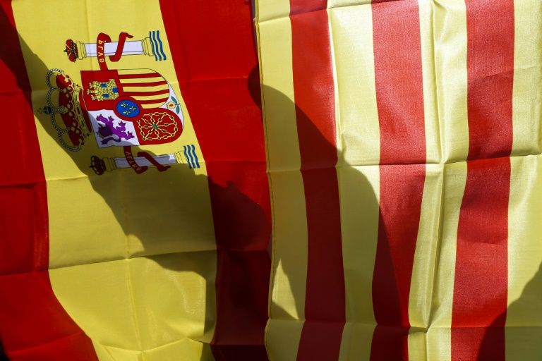 A protestor holds Spanish and Catalan flags during a demonstration against independence in Catalonia called by the far-right party'Platform for Catalonia  in front of the city hall of Barcelona