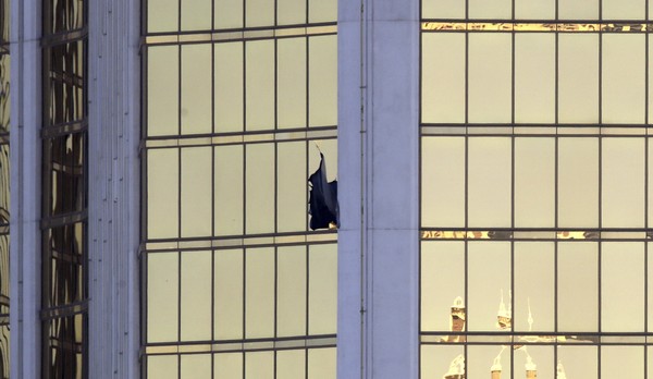 A broken window is seen at the Mandalay Bay resort and casino Monday Oct. 2 2017 on the Las Vegas Strip following a mass shooting at a music festival in Las Vegas. Authorities say Stephen Craig Paddock broke the window and began firing with a cache