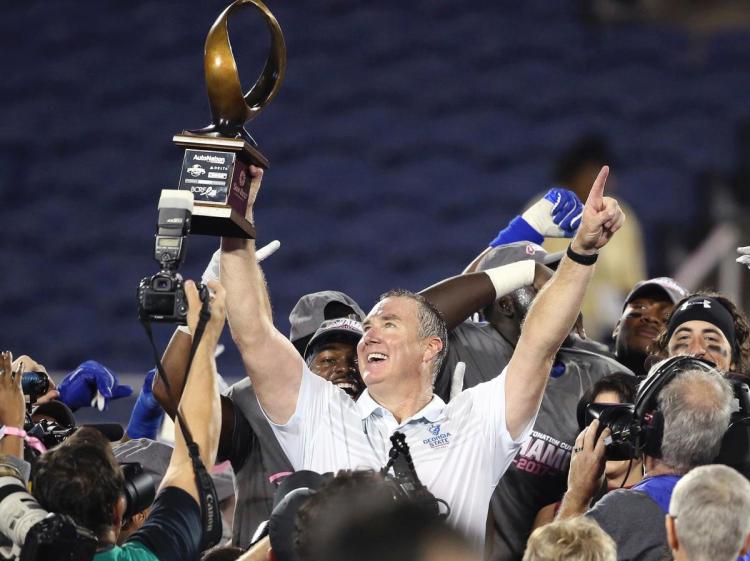 Georgia State head coach Sean Elliott hoists the championship trophy after winning the Cure Bowl NCAA college football game against Western Kentucky Saturday Dec. 16 2017 in Orlando Fla. Georgia State won 27-17. (Stephen M. Dowell  Orlando Sentinel via