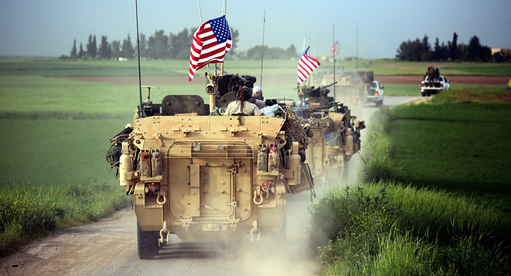 US forces accompanied by Kurdish People's Protection Units fighters drive their armoured vehicles near the northern Syrian village of Darbasiyah on the border with Turkey