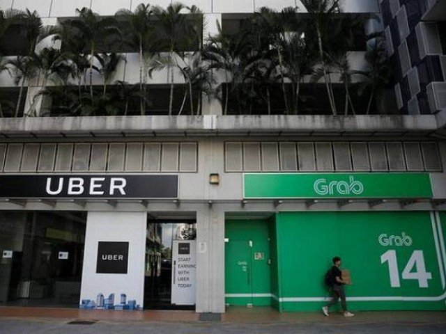 A Comfort Delgro taxi passes Uber and Grab offices in Singapore