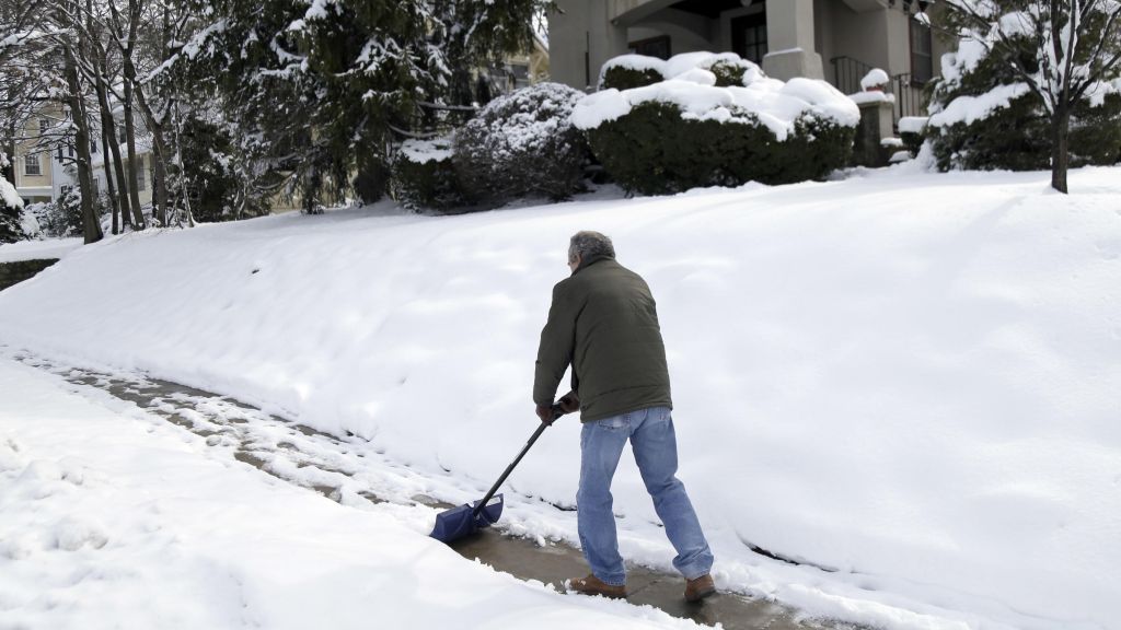 Mark Goldstein shovels the sidewalk in front of his house in Leonia N.J. Thursday after a spring nor'easter dumped up to a foot or more of snow across the region