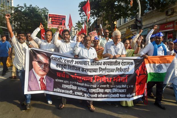 Dalit activist and supporters hold placards and raise slogans during a protest march against the alleged dilution of Scheduled Castes  Scheduled Tribes Act in Mumbai on Monday