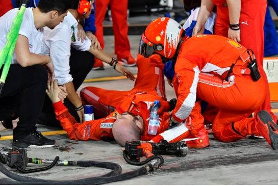 Ferrari mechanic Francesco lies on the ground after being bitted by Ferrari driver Kimi Raikkonen during a pit stop the Bahrain Formula One Grand Prix at the Formula One Bahrain International Circuit in Sakhir Bahrain Sunday