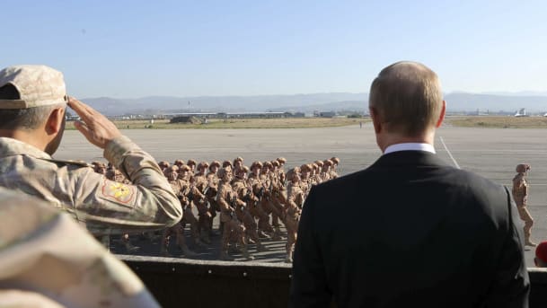 Putin watches the troops marching as he and Syrian President Bashar Assad visit the Hemeimeem air base in Syria