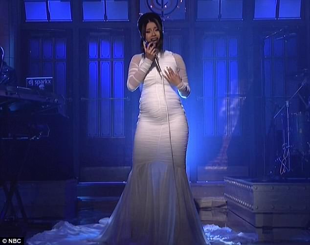 The big reveal Cardi made her announcement in style- by wearing a form-fitting dress on SNL