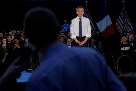 French President Emmanuel Macron listens to a question from a student in the audience during a town hall meeting at George Washington University in Washington