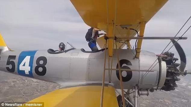 Zero gravity: She prepares to get out of the biplane. She described the feeling of walking on the upside-down plane as like being'light as a feather