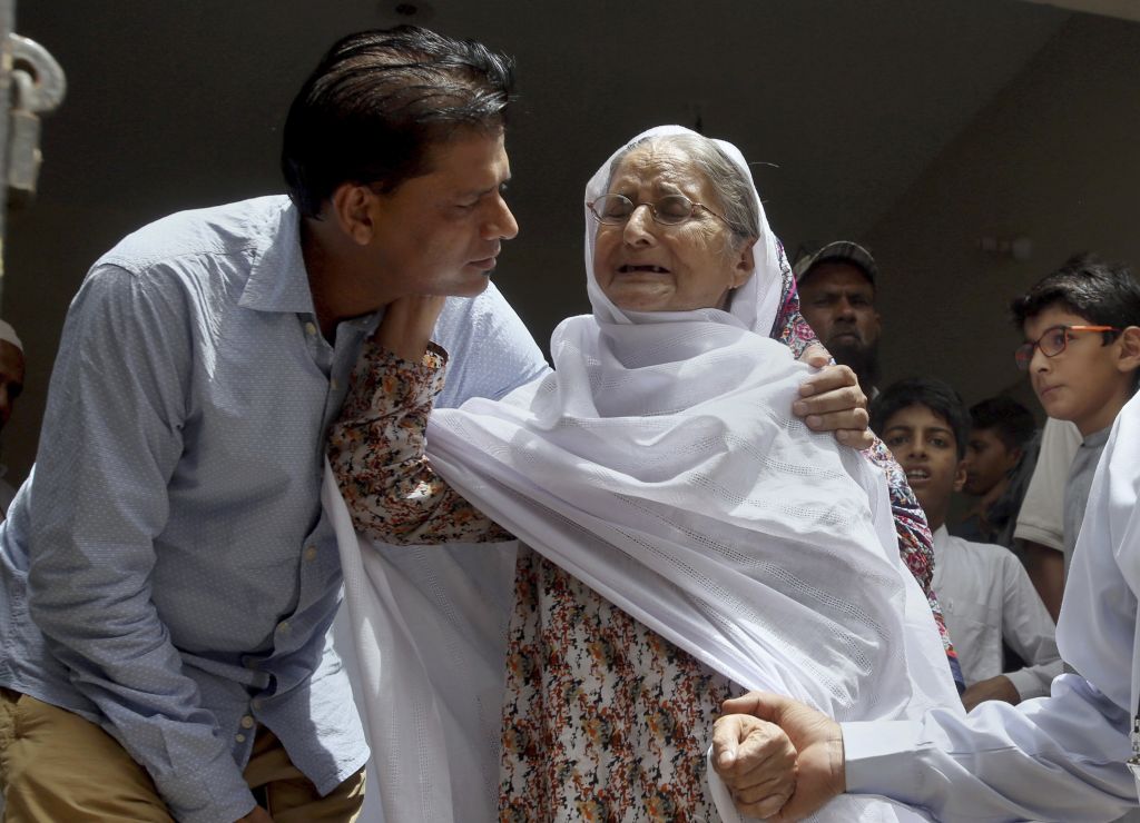 Abdul Aziz Sheikh comforts an elderly woman upon the news his daughter has died in a US school shooting