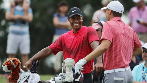 A relaxed Tiger Woods shares a laugh with playing partner Jordan Spieth during the final round of The Players