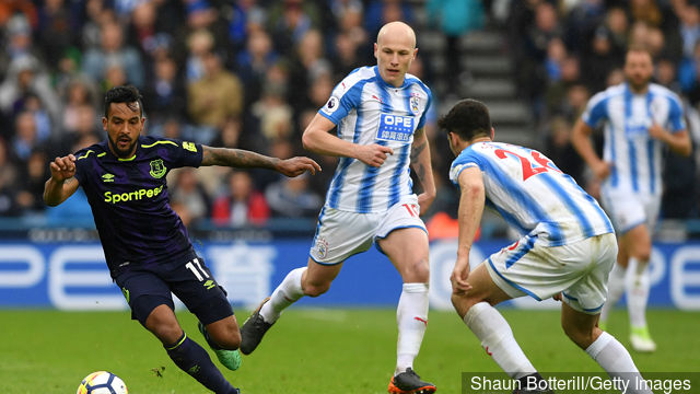 Aaron Mooy and Christopher Schindler of Huddersfield Town put pressure on Theo Walcott of Everton during the Premier League match between Huddersfield Town and Everton at John Smith's