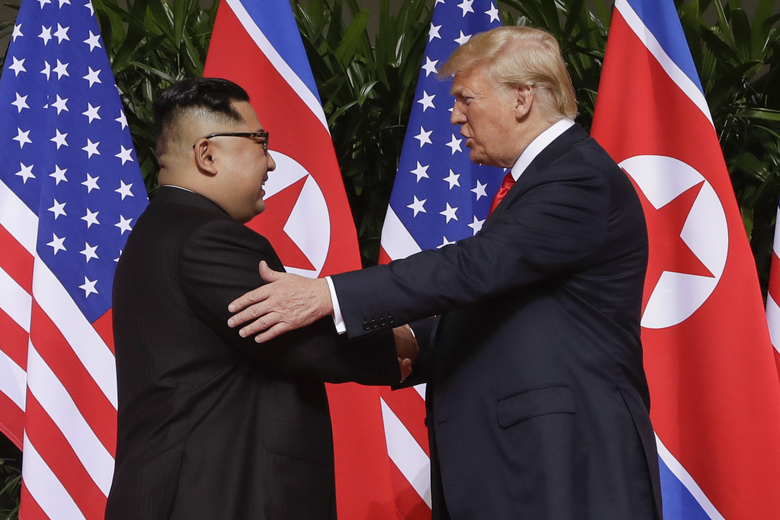 U. S. President Donald Trump shakes hands with North Korea leader Kim Jong Un at the Capella resort on Sentosa Island Tuesday