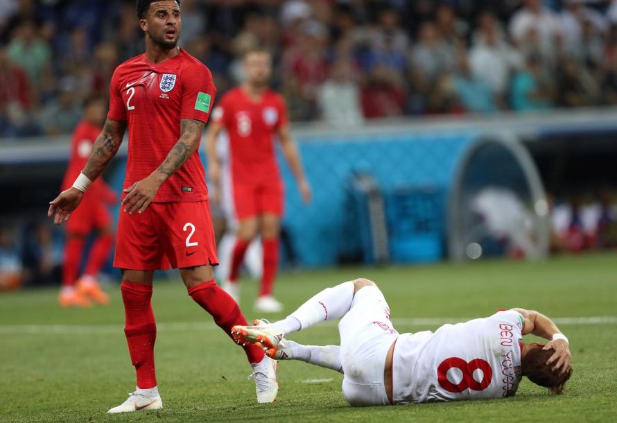 Kyle Walker looks nervously towards the match officials after bringing down Syam Ben Youssef of Tunisia