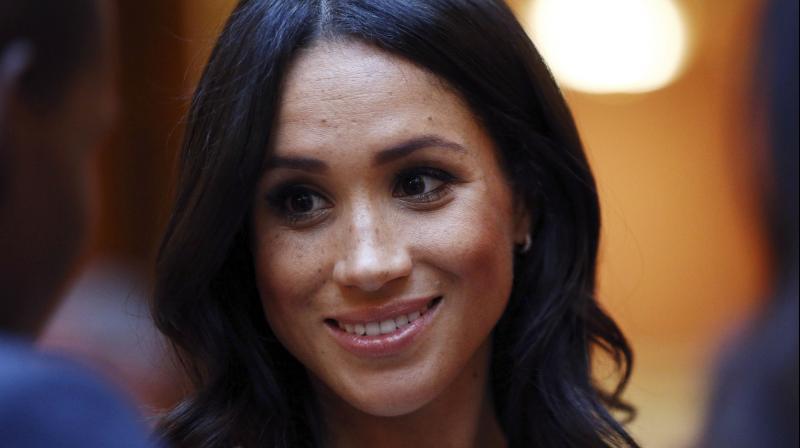 Meghan Duchess of Sussex speaks to guests at the Queen's Young Leaders Awards Ceremony hosted by Britain's Queen Elizabeth II and the Duke and Duchess of Sussex at Buckingham Palace in London Tuesday