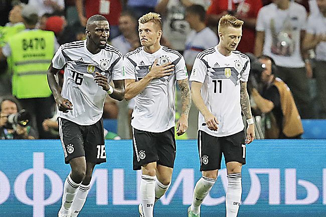 Toni Kroos celebrates with teammates Antonio Ruediger and Marco Reus. – AP