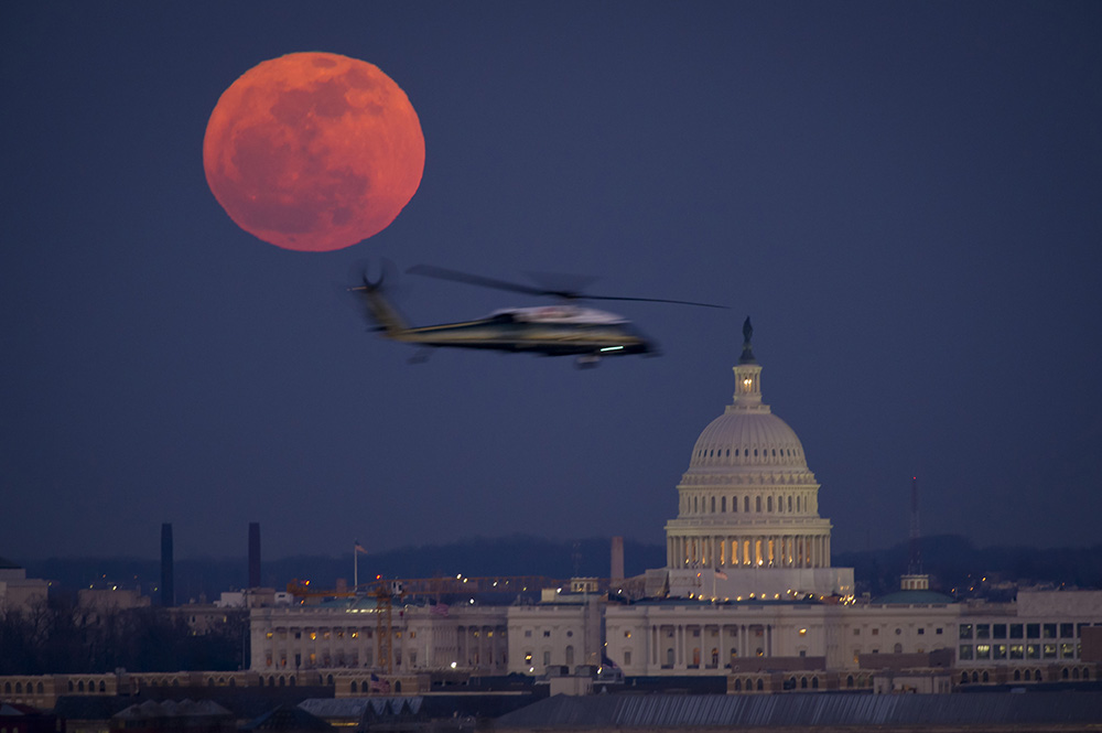 A United States Marine Corps helicopter is seen flying through this scene of the full Moon and the U.S. Capitol in 2012