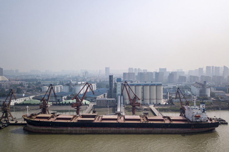 Grain is unloaded from a bulk carrier ship docked at the Nantong Cereals & Oils Transfer Co. facility at the Port of Nantong in Nantong China